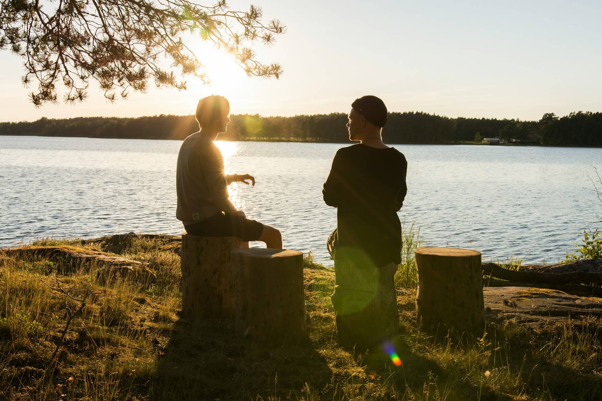 Two guys talking while sitting by the lake