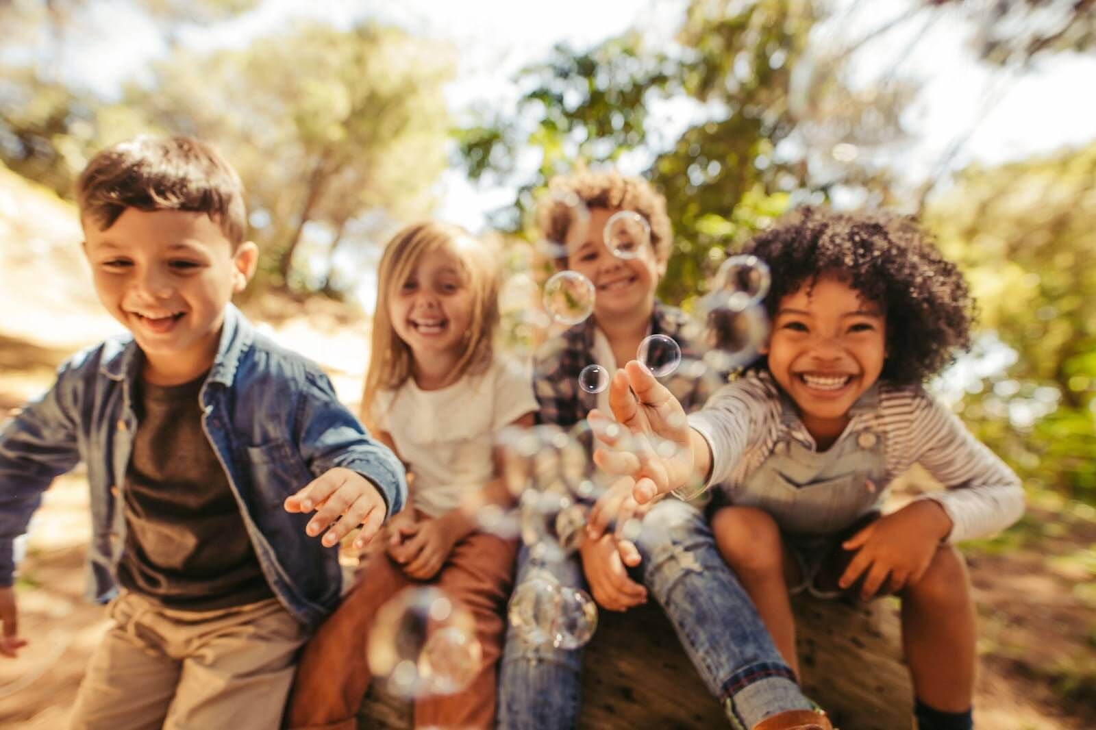 Happy children playing with soap bubbles.