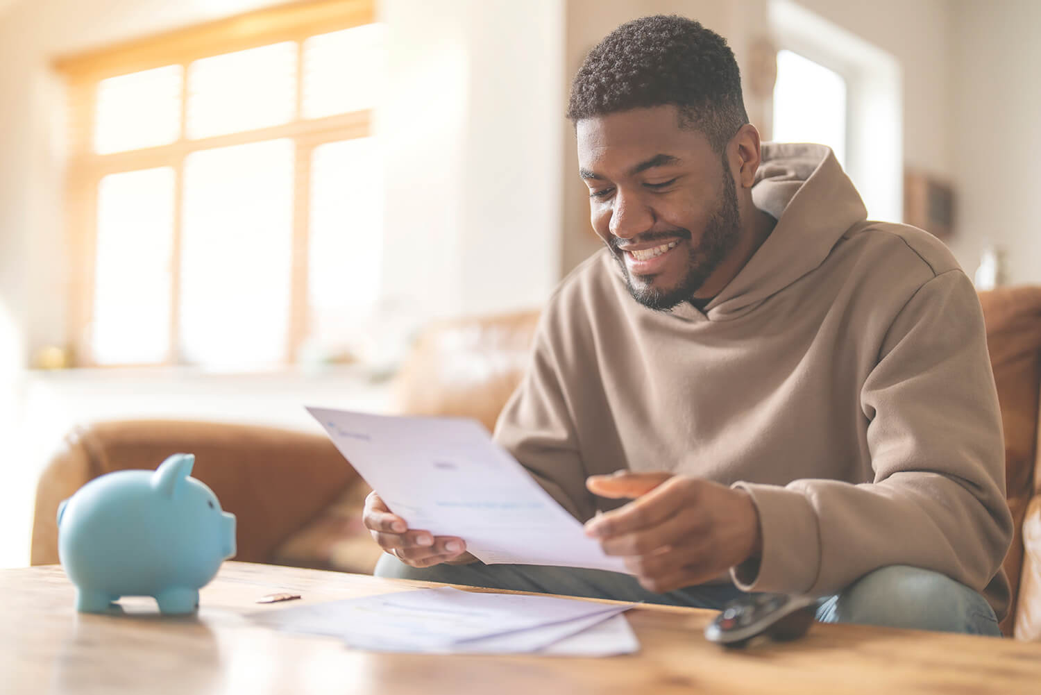 A man holding a loan contract next to a piggy bank