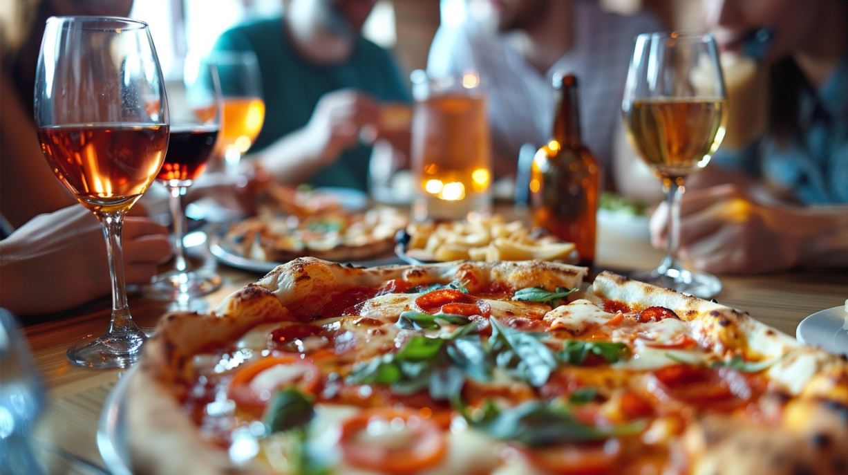 A group of people eating pizza and drinking wine